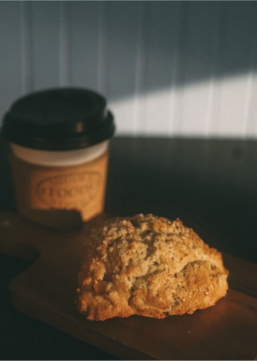 Freshly baked golden-brown scone served on a rustic wooden board.