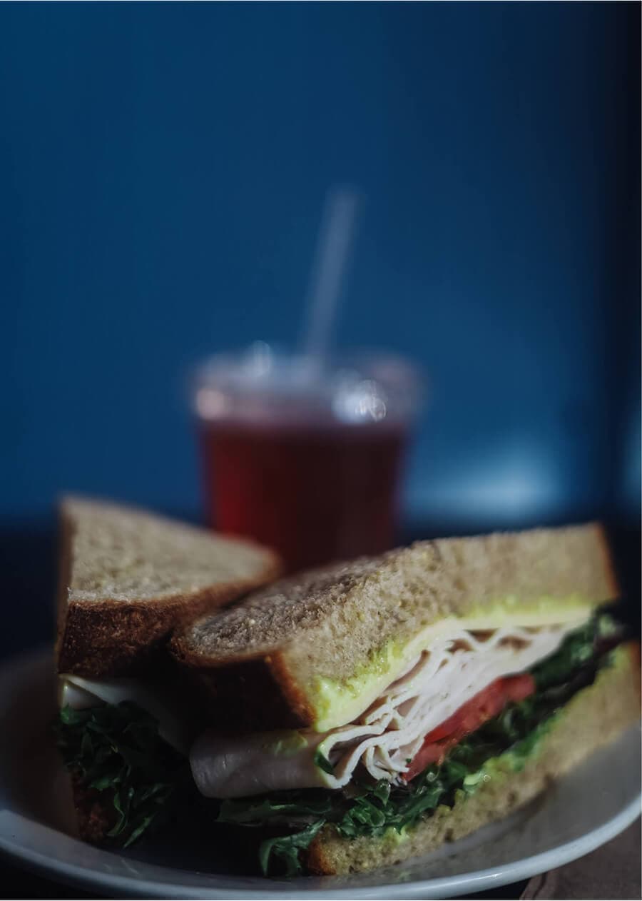 Turkey and Havarti sandwich on thick-cut wheat bread with fresh greens.